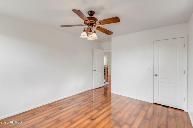 unfurnished bedroom with ceiling fan, baseboards, and wood finished floors