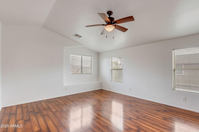 spare room with a ceiling fan, lofted ceiling, wood finished floors, and visible vents