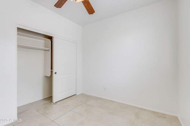 unfurnished bedroom with ceiling fan, a closet, baseboards, and light tile patterned flooring