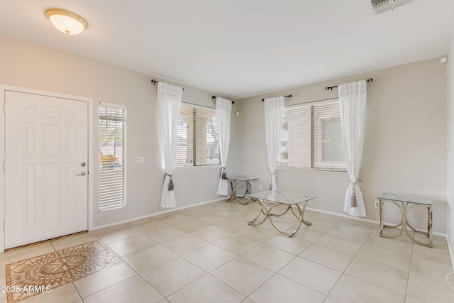 foyer entrance featuring light tile patterned floors, visible vents, and baseboards