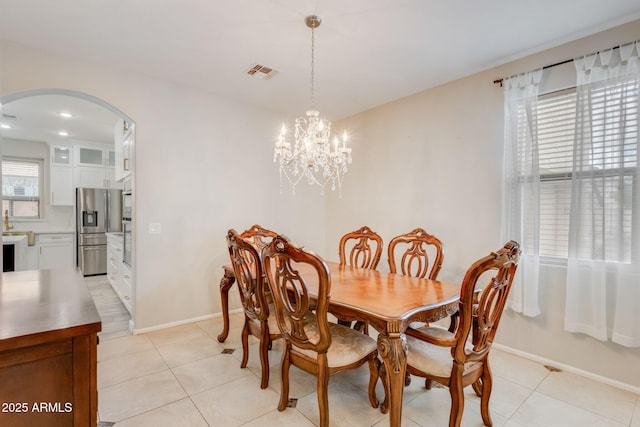 dining space with visible vents, arched walkways, an inviting chandelier, and light tile patterned flooring