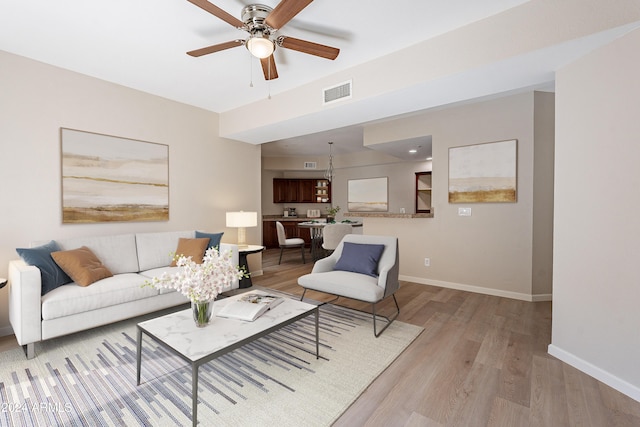 living room featuring ceiling fan and light hardwood / wood-style floors