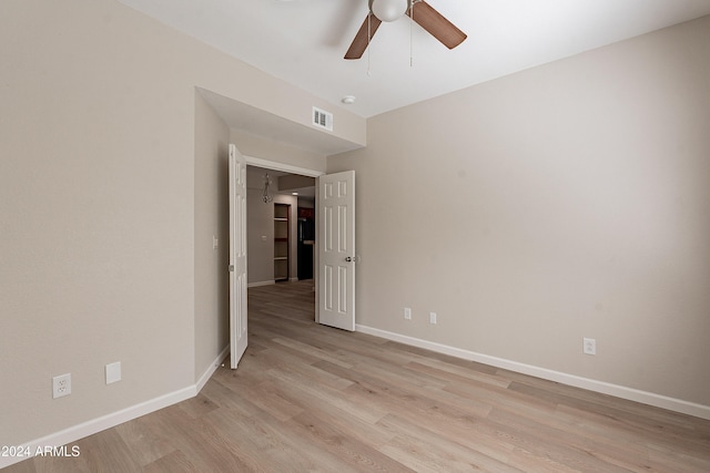 empty room with ceiling fan and light hardwood / wood-style flooring