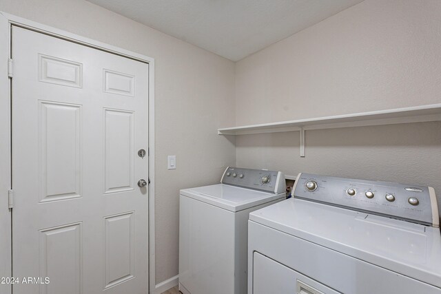 clothes washing area with washer and clothes dryer