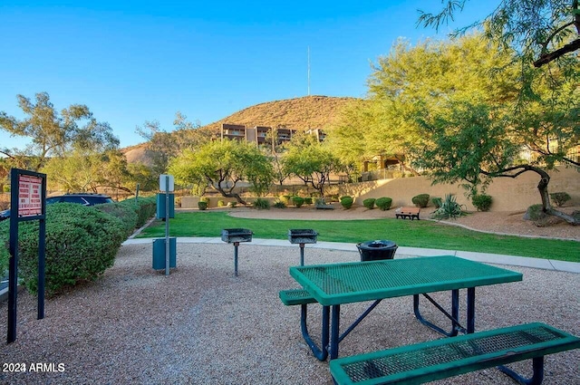 view of home's community with a mountain view and a yard