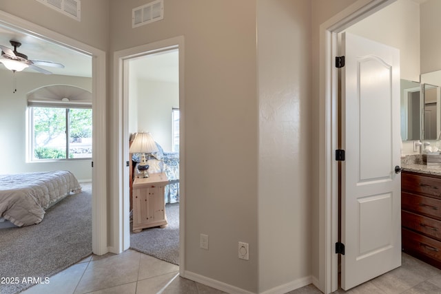 bedroom featuring light carpet, baseboards, visible vents, and light tile patterned flooring
