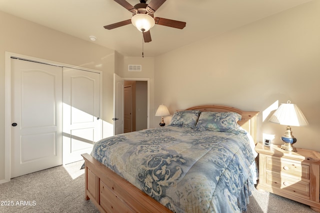 carpeted bedroom with visible vents, a closet, and ceiling fan