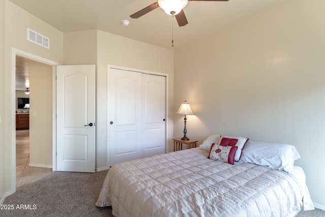 bedroom featuring a closet, carpet flooring, baseboards, visible vents, and ceiling fan