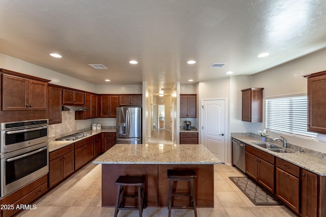 kitchen with a sink, visible vents, a center island, and appliances with stainless steel finishes