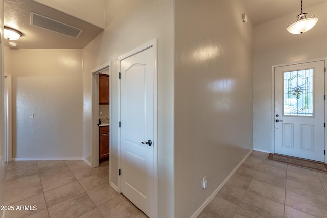 entryway with baseboards, visible vents, and light tile patterned floors