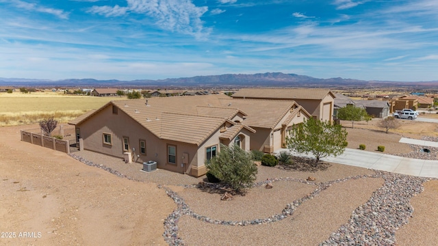 ranch-style house with stucco siding, driveway, a mountain view, and a tile roof