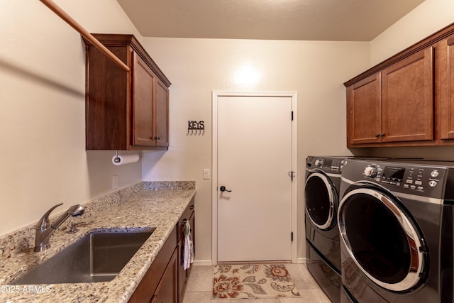 washroom featuring light tile patterned flooring, cabinet space, a sink, and separate washer and dryer