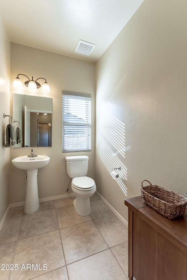 bathroom with toilet, tile patterned floors, baseboards, and visible vents