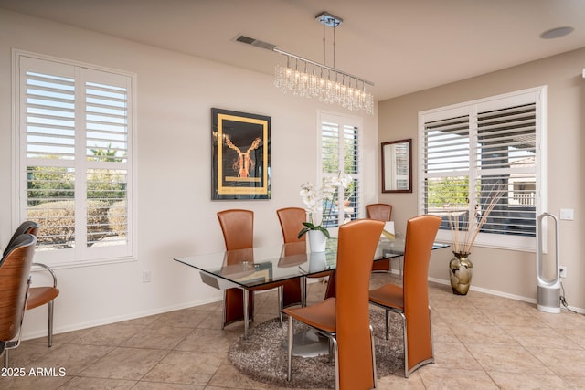 dining space featuring light tile patterned floors and a notable chandelier