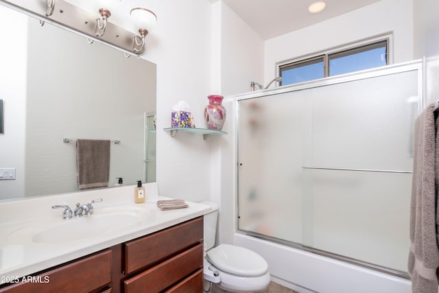 full bathroom with vanity, bath / shower combo with glass door, and toilet