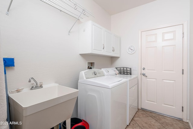 laundry area featuring cabinets, washer and clothes dryer, sink, and light tile patterned floors