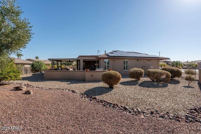 back of property featuring solar panels