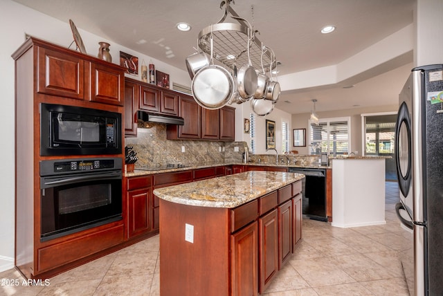 kitchen featuring a center island, kitchen peninsula, pendant lighting, decorative backsplash, and black appliances