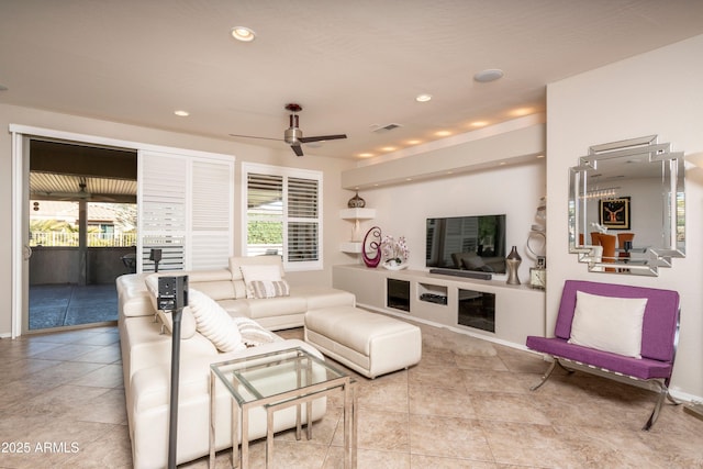 tiled living room with a wealth of natural light and ceiling fan