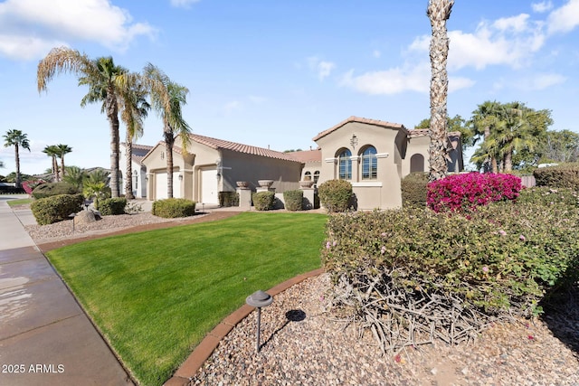 mediterranean / spanish home featuring a garage and a front lawn