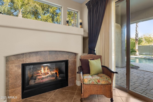 living area featuring a fireplace, a healthy amount of sunlight, and tile patterned flooring