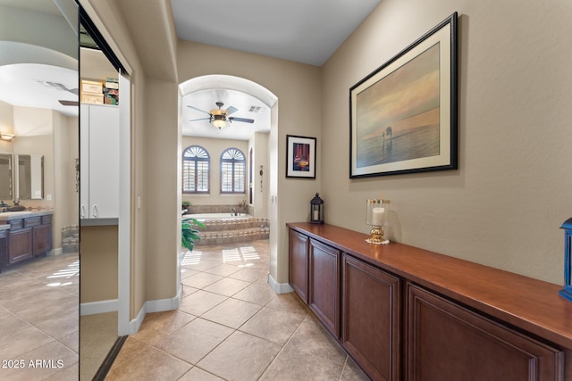 foyer entrance featuring ceiling fan, sink, and light tile patterned floors