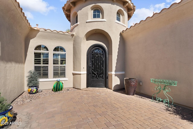 view of exterior entry with a patio area