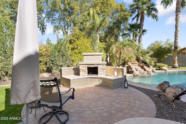 view of patio / terrace with pool water feature, an outdoor stone fireplace, and a fenced in pool