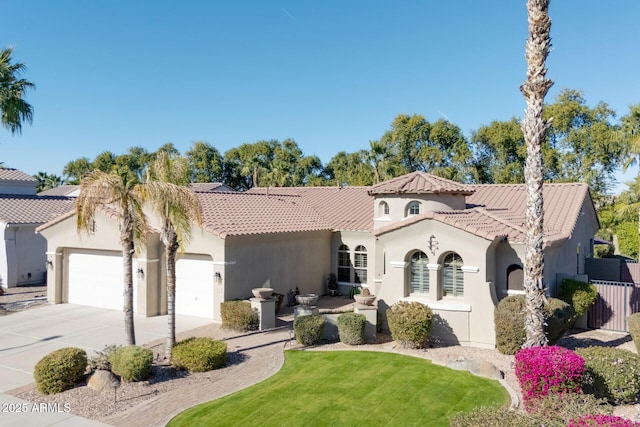 mediterranean / spanish-style house featuring a front yard and a garage