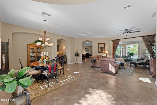 living room with tile patterned flooring and ceiling fan with notable chandelier