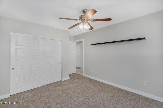 unfurnished bedroom featuring a closet, carpet, baseboards, and a ceiling fan