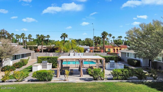 pool featuring a patio, a fenced backyard, and exterior kitchen
