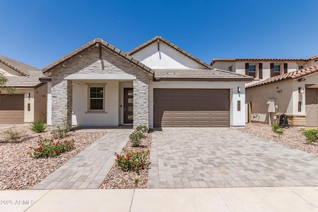 19434 S 212th Pl, Queen Creek, AZ 85142 - view of front of property featuring a garage, stucco siding, decorative driveway, stone siding, and a tile roof