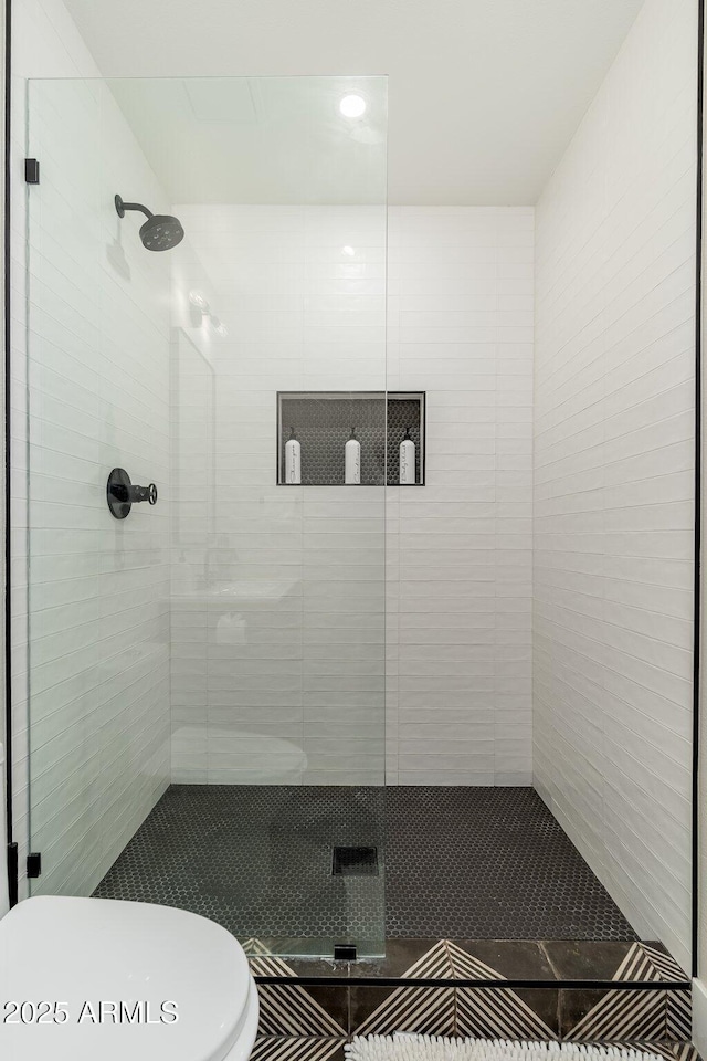 full bathroom featuring toilet and a stall shower
