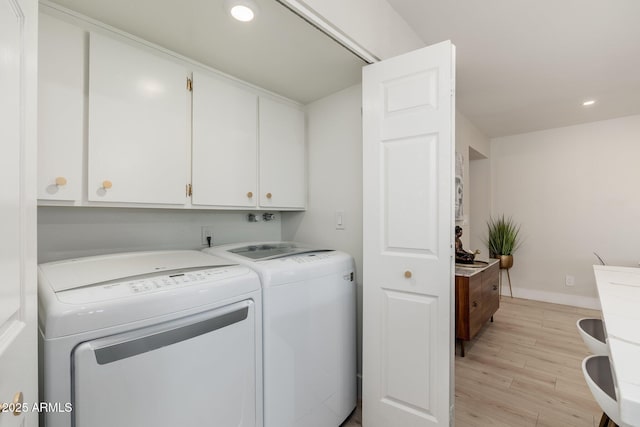 clothes washing area with recessed lighting, cabinet space, light wood-style floors, washing machine and dryer, and baseboards