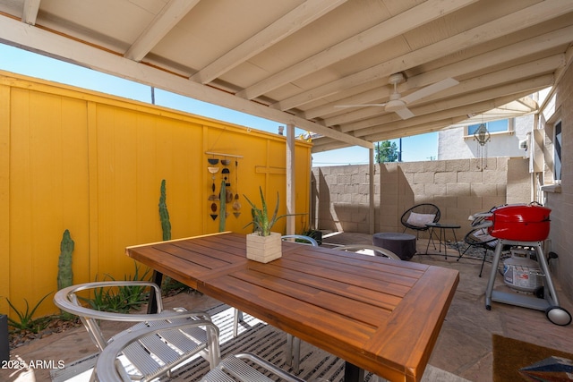 view of patio with fence, outdoor dining space, and a ceiling fan