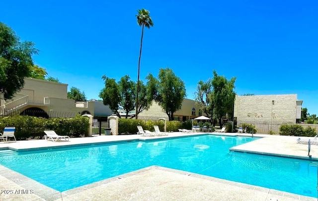 community pool featuring fence and a patio area