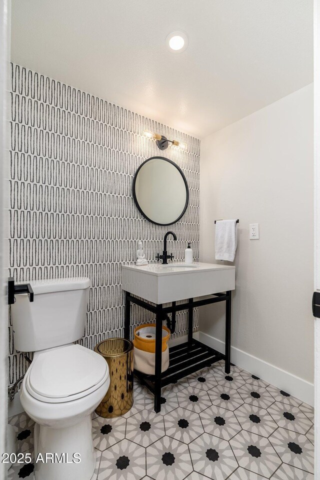 bathroom featuring recessed lighting, tile walls, toilet, a sink, and baseboards