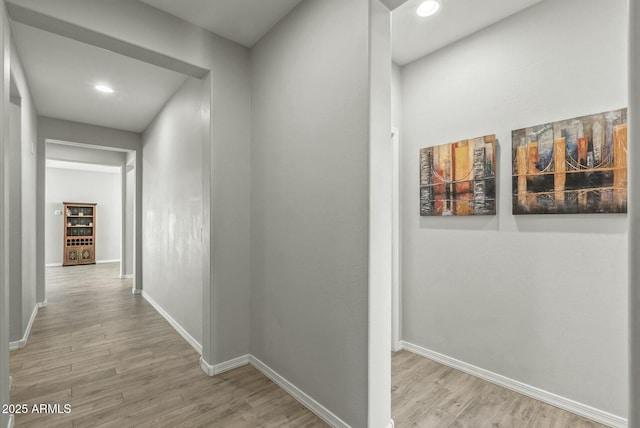 hall featuring recessed lighting, wood finished floors, and baseboards