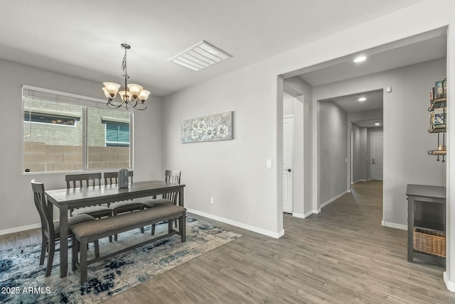 dining room with baseboards, a notable chandelier, and wood finished floors