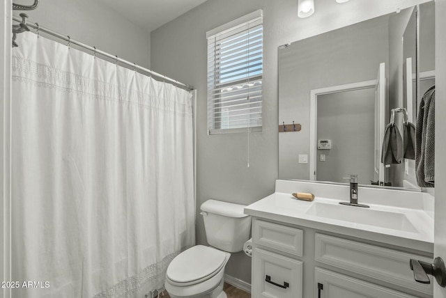 full bath featuring toilet, vanity, and curtained shower