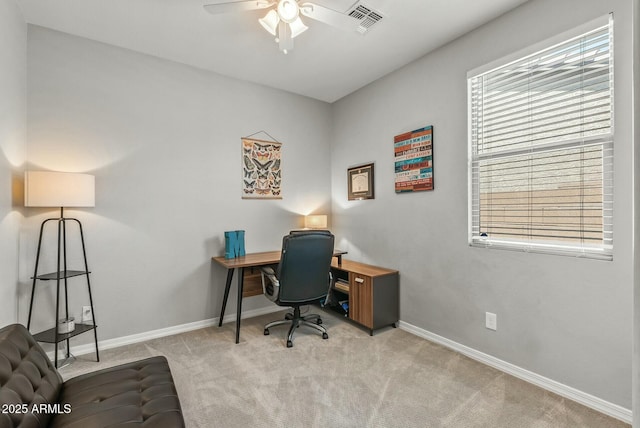 office with visible vents, a ceiling fan, baseboards, and light carpet