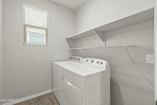 washroom with separate washer and dryer, baseboards, light wood finished floors, and laundry area