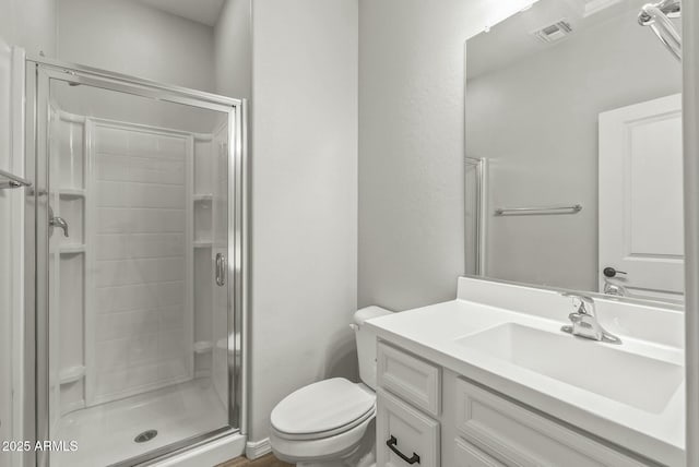 full bathroom featuring a stall shower, visible vents, vanity, and toilet