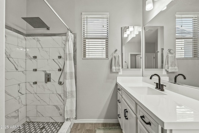 bathroom featuring baseboards, a wealth of natural light, and a stall shower