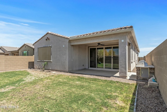 back of property with a fenced backyard, a patio area, a lawn, and a ceiling fan