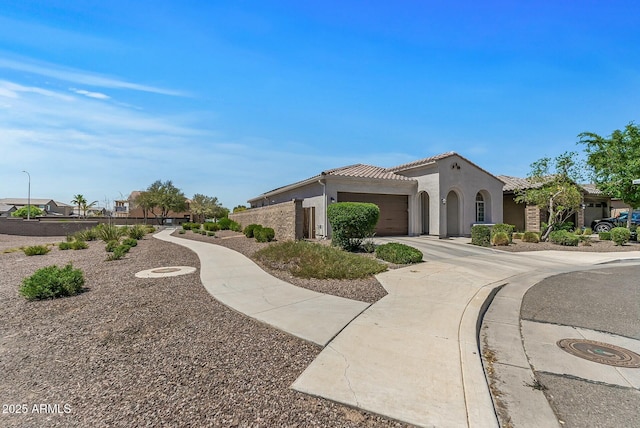 view of side of property with a garage, concrete driveway, a tiled roof, and stucco siding