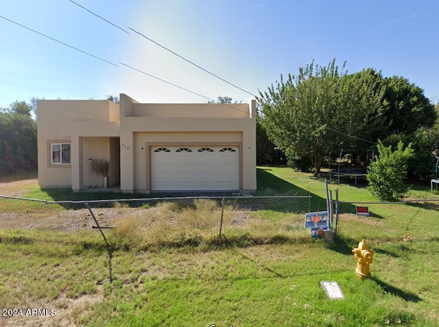 garage with a yard and a trampoline