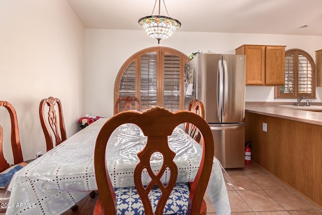 dining space featuring light tile patterned floors, sink, and a notable chandelier