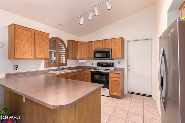 kitchen with kitchen peninsula, stainless steel appliances, lofted ceiling, and sink